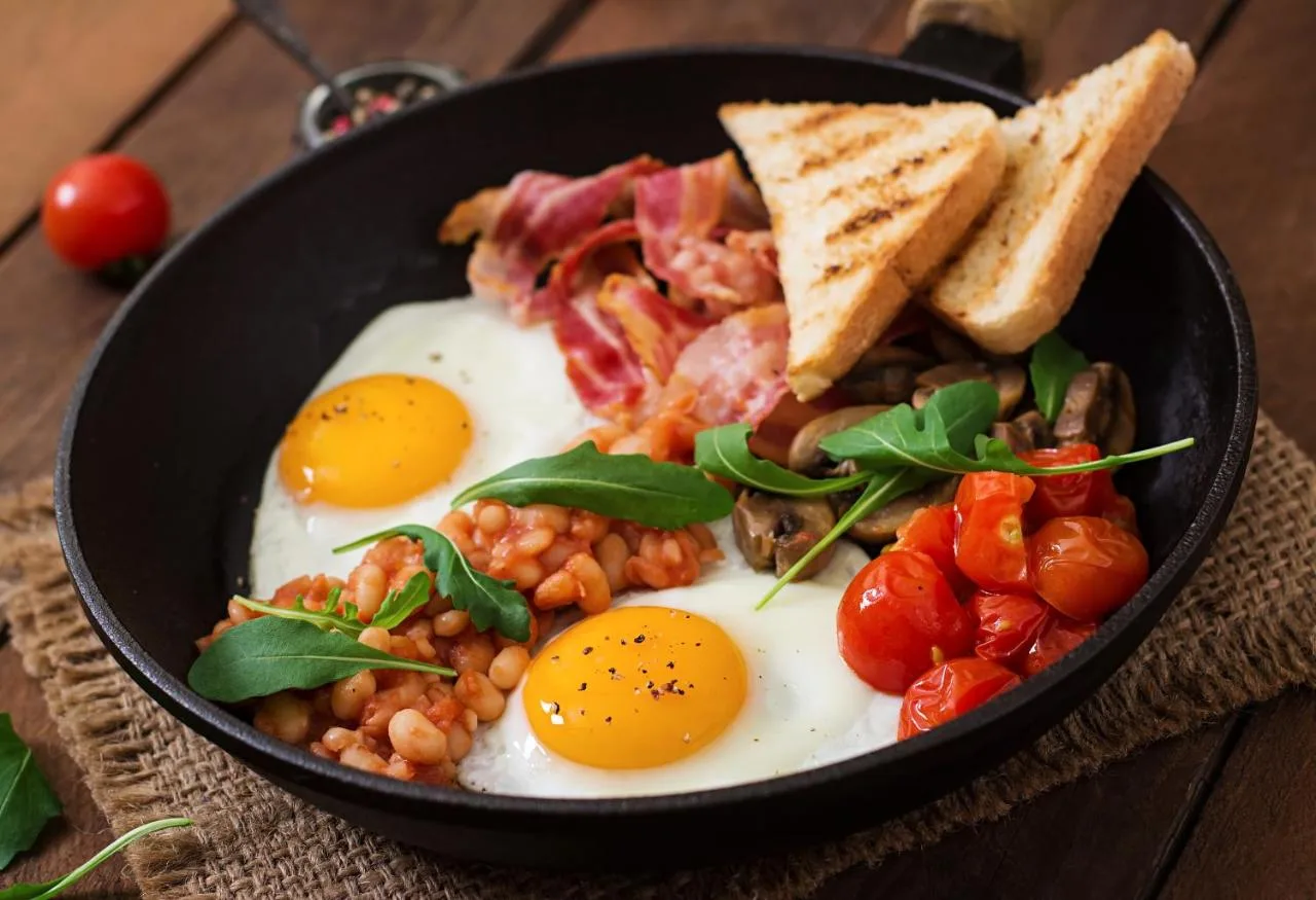 a skillet with eggs and beans and toast on a table at The Haymarket Hotel in Edinburgh